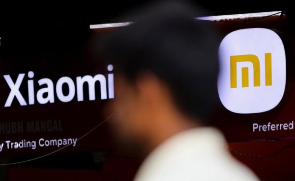 A man walks past a logo of Xiaomi, a Chinese manufacturer of co<em></em>nsumer electronics, outside a shop in Mumbai